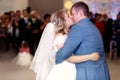 Happy beautiful newlyweds dance in restaurant