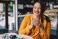 Happy beautiful plus size woman smiling and drinking coffee in cafe