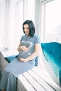 Happy beautiful pregnant caucasian woman with big belly in dress in the child room with balloons, future parrents Royalty Free Stock Photo