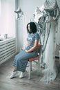 Happy beautiful pregnant caucasian woman with big belly in dress in the child room with balloons, future parrents Royalty Free Stock Photo