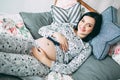 Happy beautiful pregnant caucasian woman with big belly in pajamas in the bedroom, future parrents, waiting for a child Royalty Free Stock Photo