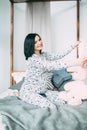 Happy beautiful pregnant caucasian woman with big belly in pajamas in the bedroom, future parrents, waiting for a child Royalty Free Stock Photo