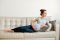 Happy beautiful pregnant young woman lying on sofa Royalty Free Stock Photo