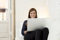 Happy beautiful 30s woman using laptop computer smiling networking at home modern living room relaxed Royalty Free Stock Photo