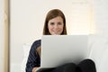 Happy beautiful 30s woman using laptop computer smiling networking at home modern living room relaxed Royalty Free Stock Photo