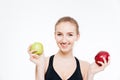 Happy beautiful sportswoman holding green and red apples Royalty Free Stock Photo