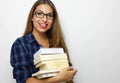 Happy beautiful student girl with eyeglasses and stack of books in her hands. Studio shot on white background. Copy space. Back to Royalty Free Stock Photo