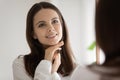 Happy beautiful teen girl looking in mirror, admiring reflection