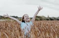 Happy beautiful tweens girl with long hair on wheat field at sunset time