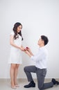 Happy beautiful Vietnamese girl looking at her boyfriend and smiling while getting a marriage proposal Royalty Free Stock Photo