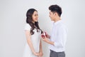 Happy beautiful Vietnamese girl looking at her boyfriend and smiling while getting a marriage proposal Royalty Free Stock Photo