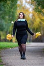 Happy beautiful woman in autumn, cute plus size model outdoors, full length portrait