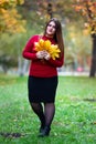 Happy beautiful woman in autumn, cute plus size model in red sweater outdoors, full length portrait