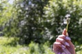 Happy beautiful woman blowing dandelion over sky background, having fun and playing outdoor, teen girl enjoying nature Royalty Free Stock Photo