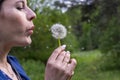 Happy beautiful woman blowing dandelion over sky background, having fun and playing outdoor, teen girl enjoying nature Royalty Free Stock Photo