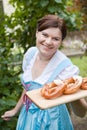 Happy beautiful woman in dirndl dress holding Oktoberfest pretz Royalty Free Stock Photo