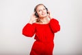 Happy beautiful woman in fashionable red dress in headphone Royalty Free Stock Photo