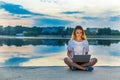 Happy beautiful woman, girl with laptop surfing the web near by lake Royalty Free Stock Photo