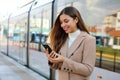 Happy beautiful woman holding cellular updating information about city transport on web page. Smiling business woman satisfied