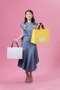 Happy beautiful woman holding many colorful shopping bags isolated on pink background Royalty Free Stock Photo