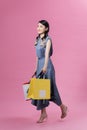 Happy beautiful woman holding many colorful shopping bags isolated on pink background Royalty Free Stock Photo