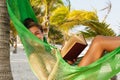 Happy and beautiful woman lying in the hammock and reading book Royalty Free Stock Photo