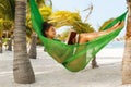 Happy and beautiful woman lying in the hammock and reading book Royalty Free Stock Photo