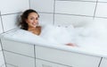 Happy Beautiful Woman Relaxing In A Bubble Bath Tub And Enjoying With Foam Bath
