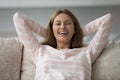 Happy beautiful woman resting leaned on sofa cushions Royalty Free Stock Photo