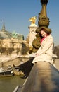 Happy beautiful woman sitting on bridge balustrade Royalty Free Stock Photo