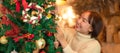 Happy beautiful woman in sweater holding santa boots and decoration to decorate on christmas tree for celebration Royalty Free Stock Photo