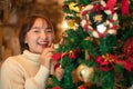 Happy beautiful woman in sweater holding santa boots and decoration to decorate on christmas tree for celebration Royalty Free Stock Photo