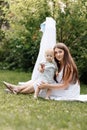 Happy beautiful woman, young mother playing with her adorable baby son, cute little boy, enjoying together a sunny warm day Royalty Free Stock Photo