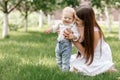 Happy beautiful woman, young mother playing with her adorable baby son, cute little boy, enjoying together a sunny warm Royalty Free Stock Photo