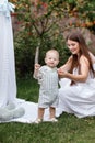 Happy beautiful woman, young mother playing with her adorable baby son, cute little boy, enjoying together a sunny warm Royalty Free Stock Photo