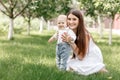 Happy beautiful woman, young mother playing with her adorable baby son, cute little boy, enjoying together a sunny warm Royalty Free Stock Photo