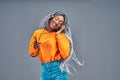 Happy beautiful young african american woman with mobile phone listening to music and dancing over grey background Royalty Free Stock Photo