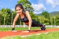 Happy beautiful young Asian woman doing push up exercise in the morning at a running track Royalty Free Stock Photo