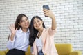 Happy beautiful young asian woman friendship selfie together , Happiness teenagers taking pictures selfie in living room Royalty Free Stock Photo