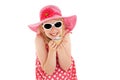 Happy, beautiful young blonde girl in big pink floppy hat and white framed sunglasses excitedly holding up a cup cake. Isolated on Royalty Free Stock Photo