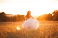 Happy beautiful young bride outside on a summer meadow at the sunset Royalty Free Stock Photo