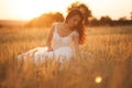 Happy beautiful young bride outside on a summer meadow at the sunset Royalty Free Stock Photo