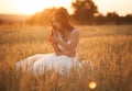 Happy beautiful young bride outside on a summer meadow at the sunset Royalty Free Stock Photo