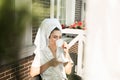 Happy beautiful young brunette woman wearing dressing gown and white towel on her head enjoying cup of coffee on the terrace Royalty Free Stock Photo