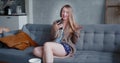 Happy beautiful young Caucasian woman smiles talking to friend from home on self isolation using smart phone video app. Royalty Free Stock Photo