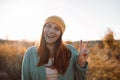 Portrait of happy beautiful young caucasian woman smiling having fun, showing peace sign outdoors at sunset in nature Royalty Free Stock Photo