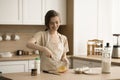 Happy beautiful young chef woman in apron preparing homemade omelet