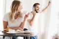 Happy beautiful young couple having breakfast at the kitchen table