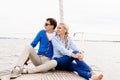 Happy and beautiful young couple sitting on deck and having a good time together. Traveling, tourism, journey, concept.