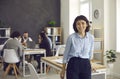 Portrait of a happy beautiful businesswoman or company worker standing in a modern office Royalty Free Stock Photo